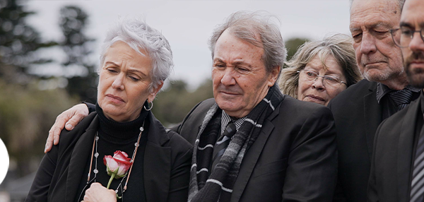 Group of older people dressed in black mourning outside