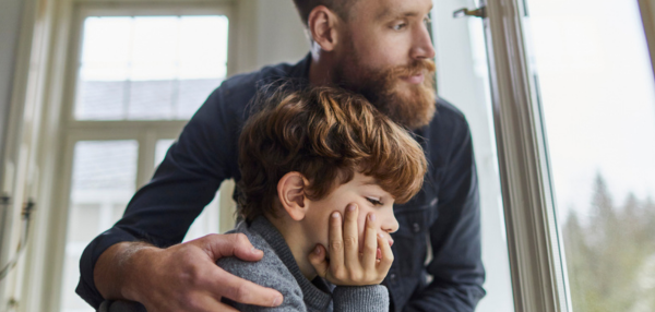 Serious father and son looking out of window