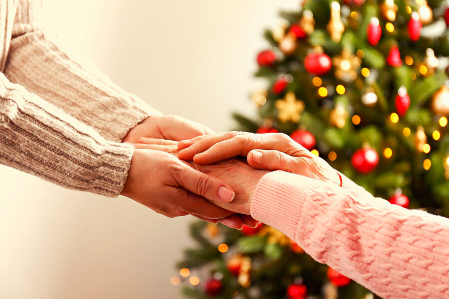 hands embracing with christmas tree in background